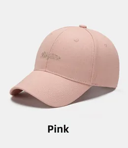 Detail of champagne gold embroidery on the side of a pink twill cotton baseball cap