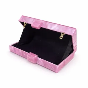 Detail view of pink marble acrylic evening clutch showing the black interior and clasp
