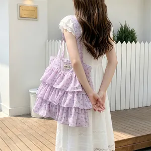 Außenaufnahme der hellvioletten Tragetasche mit Blumenmuster und gestuften Rüschen