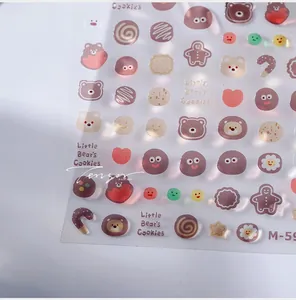 Macro view of 3D embossed nail stickers featuring cute bears and cookies on white background
