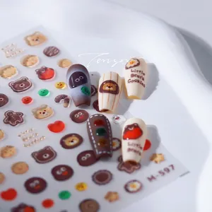 Detail of adhesive nail stickers with cute brown bear and cookie patterns, model M-597
