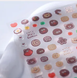 Detail of 3D cartoon bear and cookie nail stickers with a glossy embossed resin texture