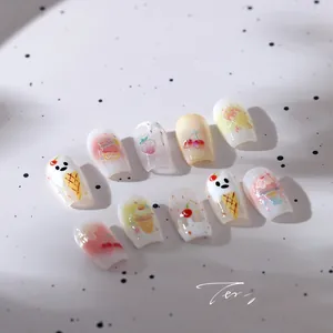 Macro detail of macaron-colored 3D nail stickers featuring dessert and fruit patterns