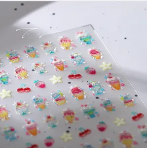 Macro shot of embossed 3D nail art stickers featuring ice cream and fruit motifs