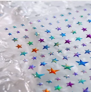 Macro shot of colorful laser glitter star nail stickers with holographic gradient effect