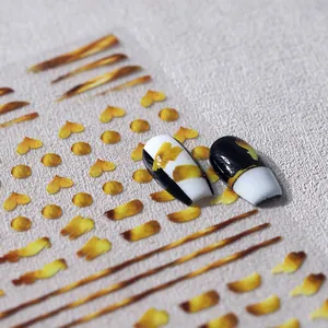 Abstract golden brushstrokes and heart nail stickers for a professional manicure look