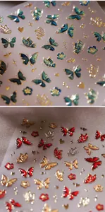 Macro shot of 3D embossed butterfly nail stickers with metallic gold borders and glitter