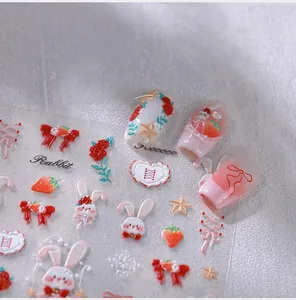Detail of 5D embossed rabbit and strawberry nail stickers showing 3D texture on nails