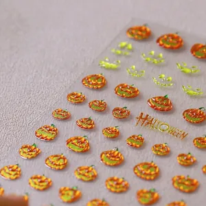 Dettaglio macro di adesivi 3D per unghie a tema Halloween con zucche e texture glitter