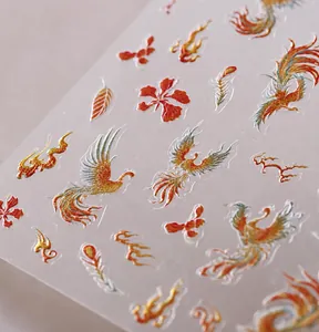 Macro-opname van 3D-reliëf nagelstickers met Chinese feniks- en bloemenpatronen in goudfolie
