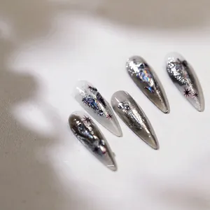 Detailed macro of silver gradient press-on nails with 3D butterfly and rhinestone accents