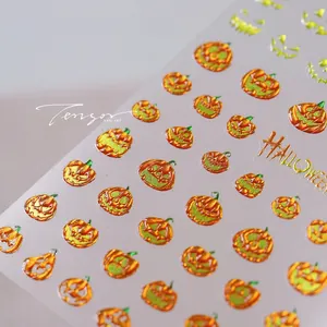 Dettaglio macro di adesivi per unghie con zucche di Halloween ed effetto metallico