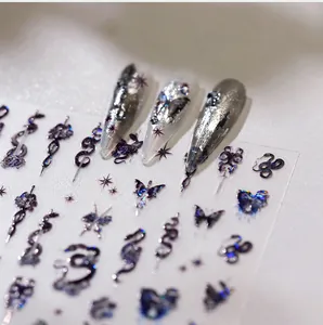 Macro detail of laser 3D embossed nail stickers featuring dark snakes and butterflies