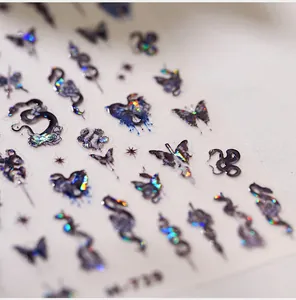 Macro detail of laser holographic nail stickers featuring snake and butterfly patterns