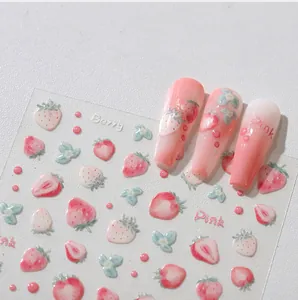 Vue détaillée des autocollants 3D fraise en relief sur ongles roses en dégradé