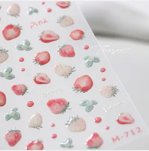 Détail macro de stickers ongles 3D en relief avec motifs de fraises roses et baies