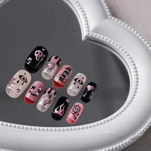 Vue macro de 10 faux ongles gothiques avec masque Scream et motifs de cœur sur miroir