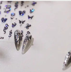 Macro shot of 3D laser nail stickers featuring dark butterfly and snake motifs