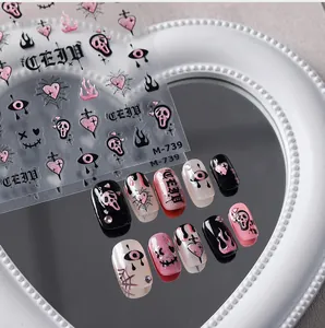 Détails d'autocollants gothiques cœurs et crânes sur ongles manucurés roses et noirs