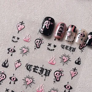 Détail macro de stickers ongles gothiques sombres avec cœurs roses et motifs flammes