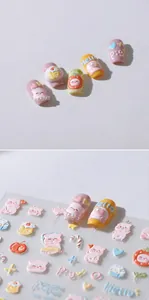 Detail of 3D embossed nail stickers featuring cute cartoon pigs and macaron fruit patterns