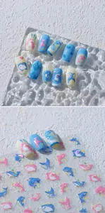 Macro view of ocean themed nail stickers with dolphin and shark patterns in pastel hues