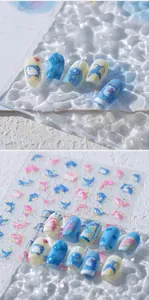 Detailed view of ocean-themed nail stickers with cute sharks and blue wave patterns