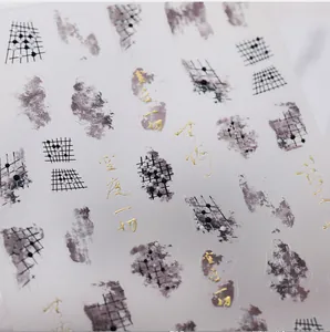 Macro detail of 3D embossed nail decals with gold foil calligraphy and ink art design