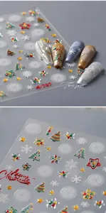 Gros plan d'autocollants 3D pour ongles de Noël avec flocons de neige et étoiles d'or