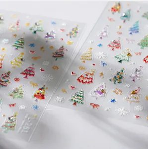 Detailed macro view of 5D embossed Christmas nail stickers with trees and snowflakes