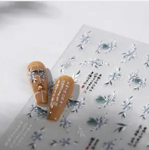 Detailed macro shot of Chinese style floral nail stickers with calligraphy and white petals