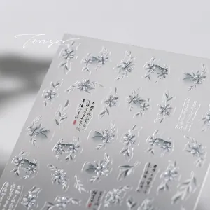 Macro detail of bronzing nail stickers with vintage floral patterns and Chinese calligraphy