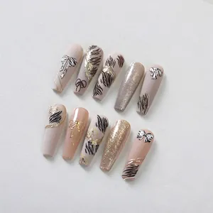 Close-up of coffin nails with zebra stripes, 3D golden bows and foil details