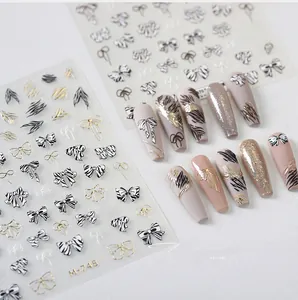 Detail of 3D embossed nail stickers featuring zebra patterns and metallic bow designs