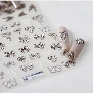 Macro detail of zebra pattern bow nail stickers on long matte pink manicure nails