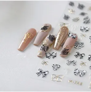 Detail of 3D embossed zebra and bow nail art stickers with elegant gold finish accents