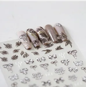 Macro detail of 5D embossed zebra and bow nail art stickers with sample manicure display