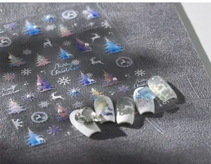 Macro shot of 5D embossed Christmas nail stickers with pearl deer and laser snowflake patterns