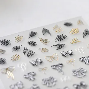3D relief nail art stickers with zebra patterns and golden bow-knots on white background