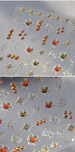 Dettaglio macro di adesivi 3D per unghie con fiori dorati e texture metallica in rilievo
