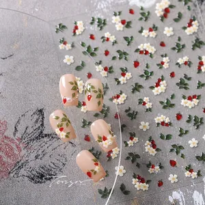 Macro shot of 3D embossed nail stickers featuring strawberry and white floral patterns