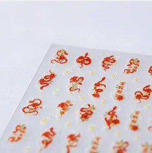 Detailed close-up of Year of the Snake red and gold embossed Chinese style nail art stickers