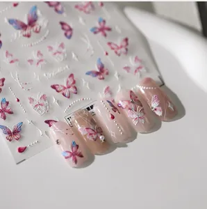 Macro detail of 5D butterfly nail stickers showing 3D embossed textures on pink nails