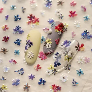 Macro shot of 3D embossed floral nail stickers with pearl accents on various nail tips
