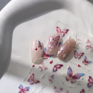 Close-up of 5D gradient butterfly nail stickers with embossed texture on pink nails