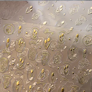 Detail showing 3D embossed tulip nail art stickers with gold foil relief and floral textures