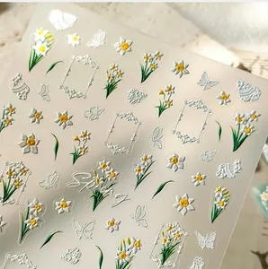 Macro detail of 5D embossed nail stickers featuring narcissus flowers and butterflies