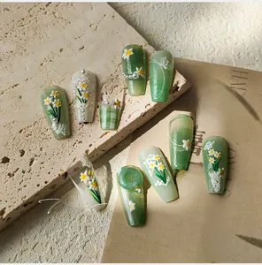 Macro detail of 3D embossed narcissus flowers and pearls on long coffin press-on nails