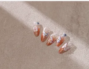 Detailed view of orange gradient butterfly nail art stickers with rhinestones and gold foil
