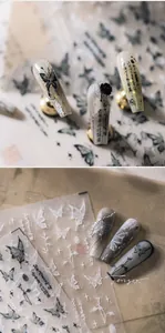 Dettaglio macro di decalcomanie 3D per unghie con farfalle e calligrafia cinese